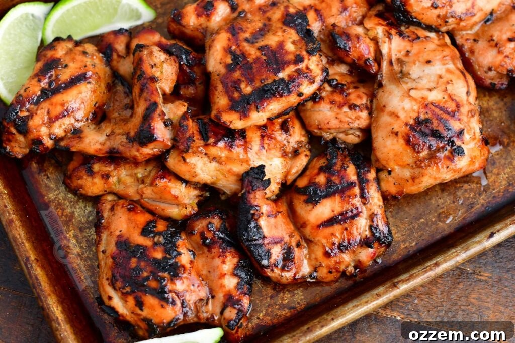 Zesty Grilled Ginger Lime Chicken Thighs 7 Grilled chicken thighs garnished with fresh lime wedges served on a sleek metal pan