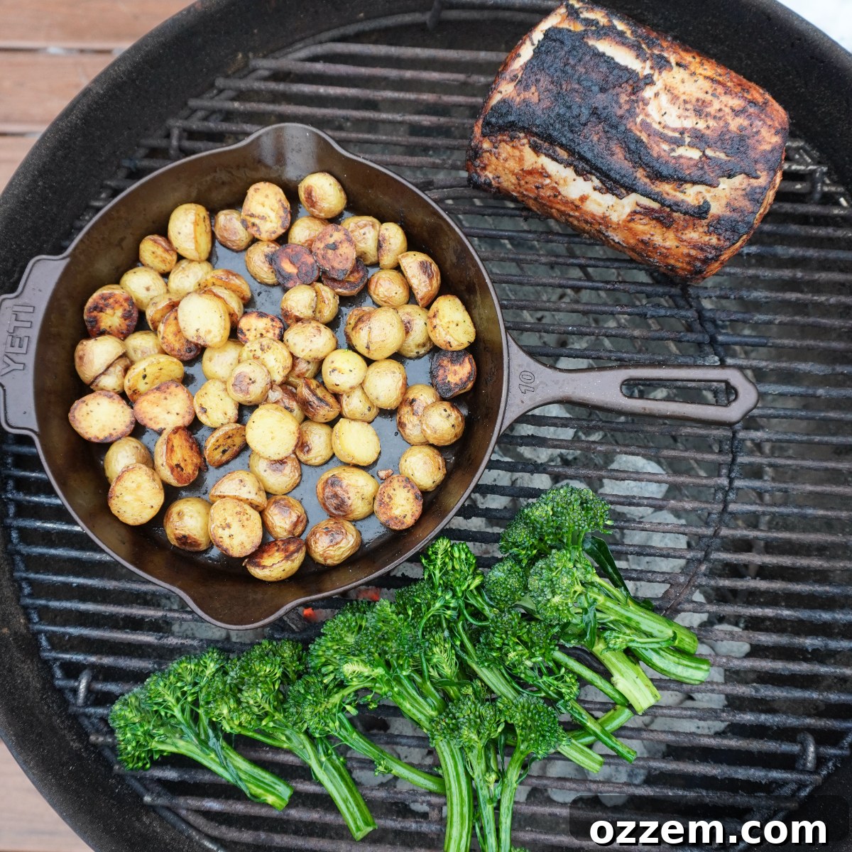 Grilled mustard pork loin, potatoes and veggies all on a charcoal grill.