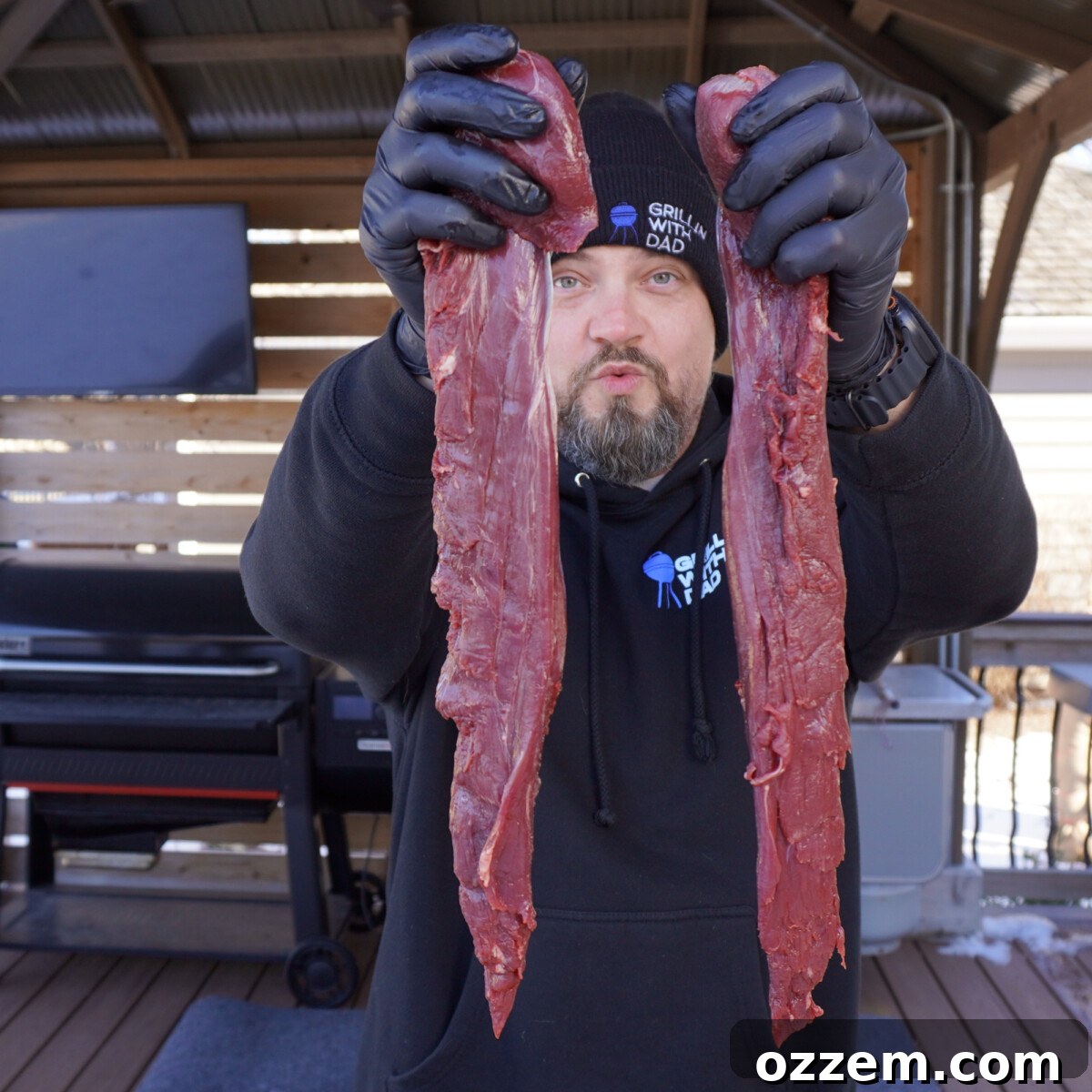 Two long strips of venison tenderloin laid out on a cutting board, illustrating the natural shape of the cut.