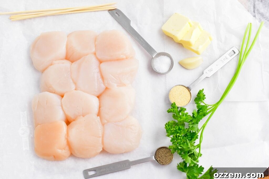 Key ingredients for grilled scallops laid out on white parchment paper: fresh scallops, garlic, parsley, butter, salt, pepper, and garlic powder.