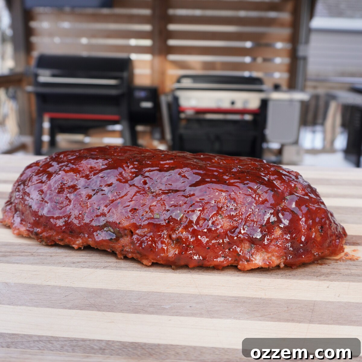 Cooked smoked meatloaf resting on a cutting board, ready to be sliced.