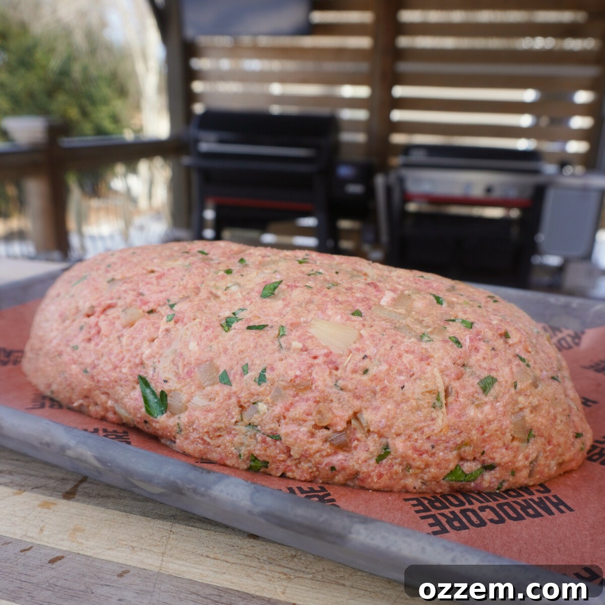 Oval-shaped raw meatloaf on a sheet pan, ready for seasoning.