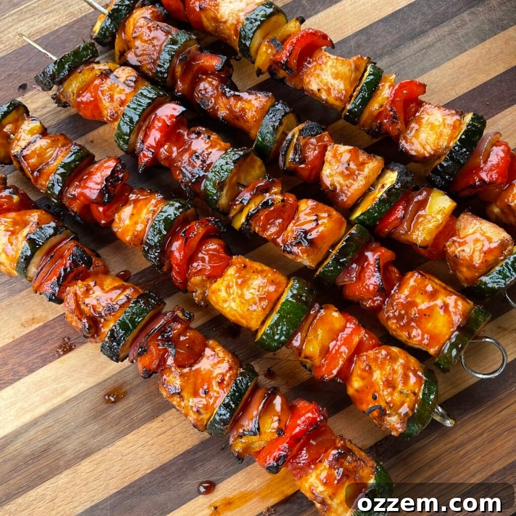 Grilled spicy chicken skewers served on a platter, showcasing vibrant colors of chicken, bell peppers, zucchini, and cherry tomatoes.