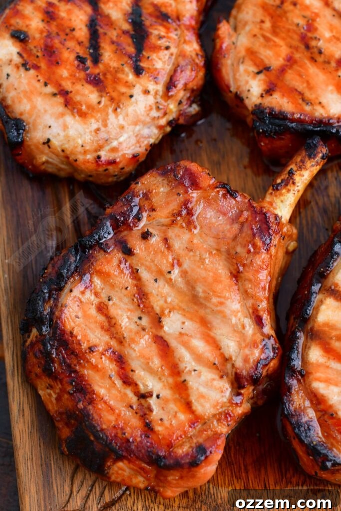 Close-up of grilled pork chops on a cutting board, showcasing their juicy interior and caramelized exterior.