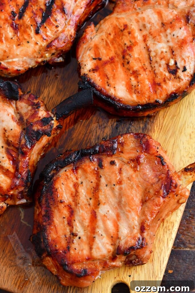 A top-down view of grilled pork chops served on a wooden plate, ready to be enjoyed.