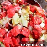 Summer Watermelon Feta Delight 12 Closeup of Watermelon Feta Salad in a glass bowl with a spoon, highlighting its freshness