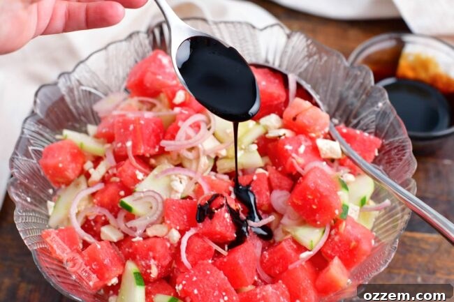 Summer Watermelon Feta Delight 9 Drizzling homemade balsamic reduction over a freshly tossed Watermelon Feta Salad in a serving bowl.