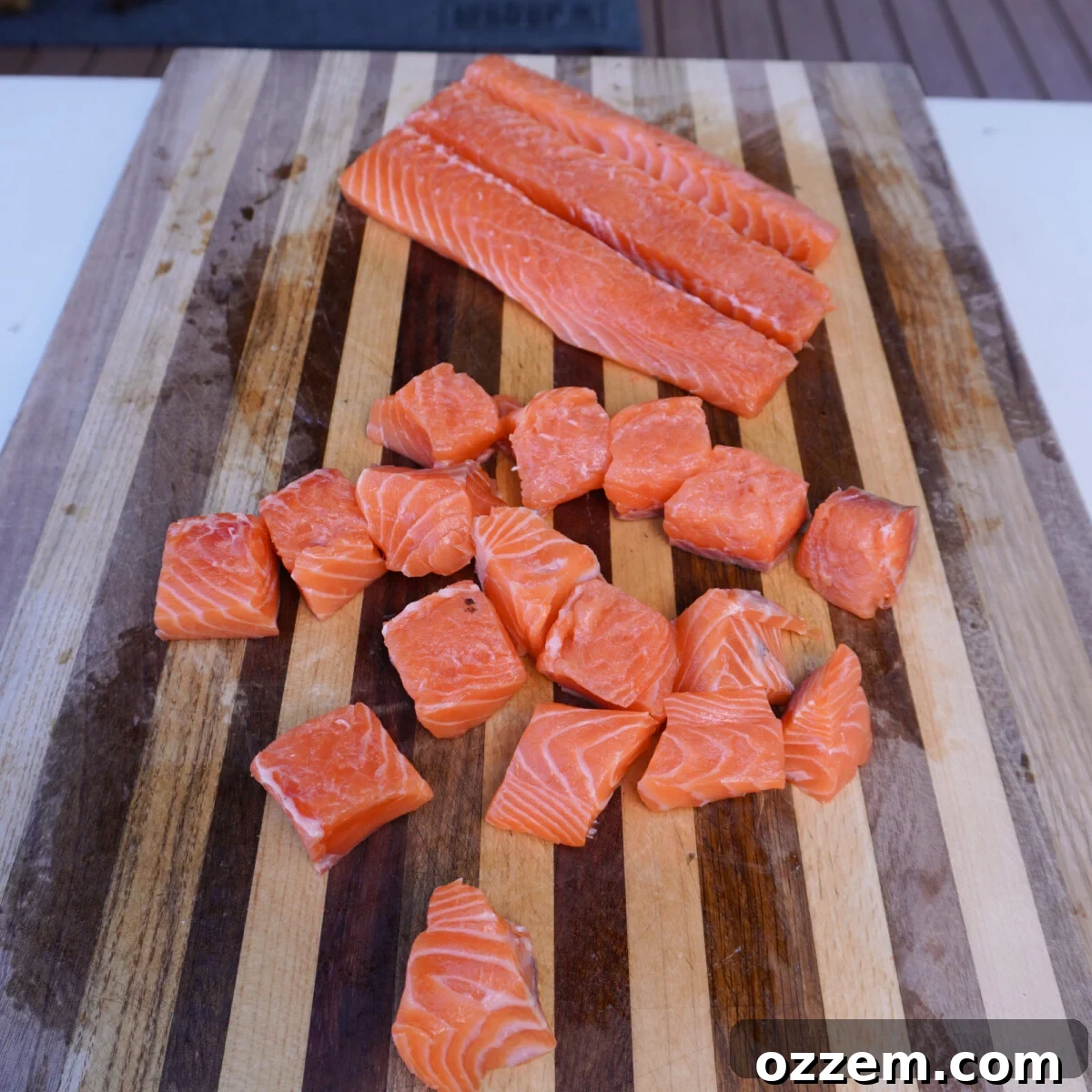 Golden Cajun Salmon Poppers 5 Perfectly cubed salmon pieces on a cutting board.