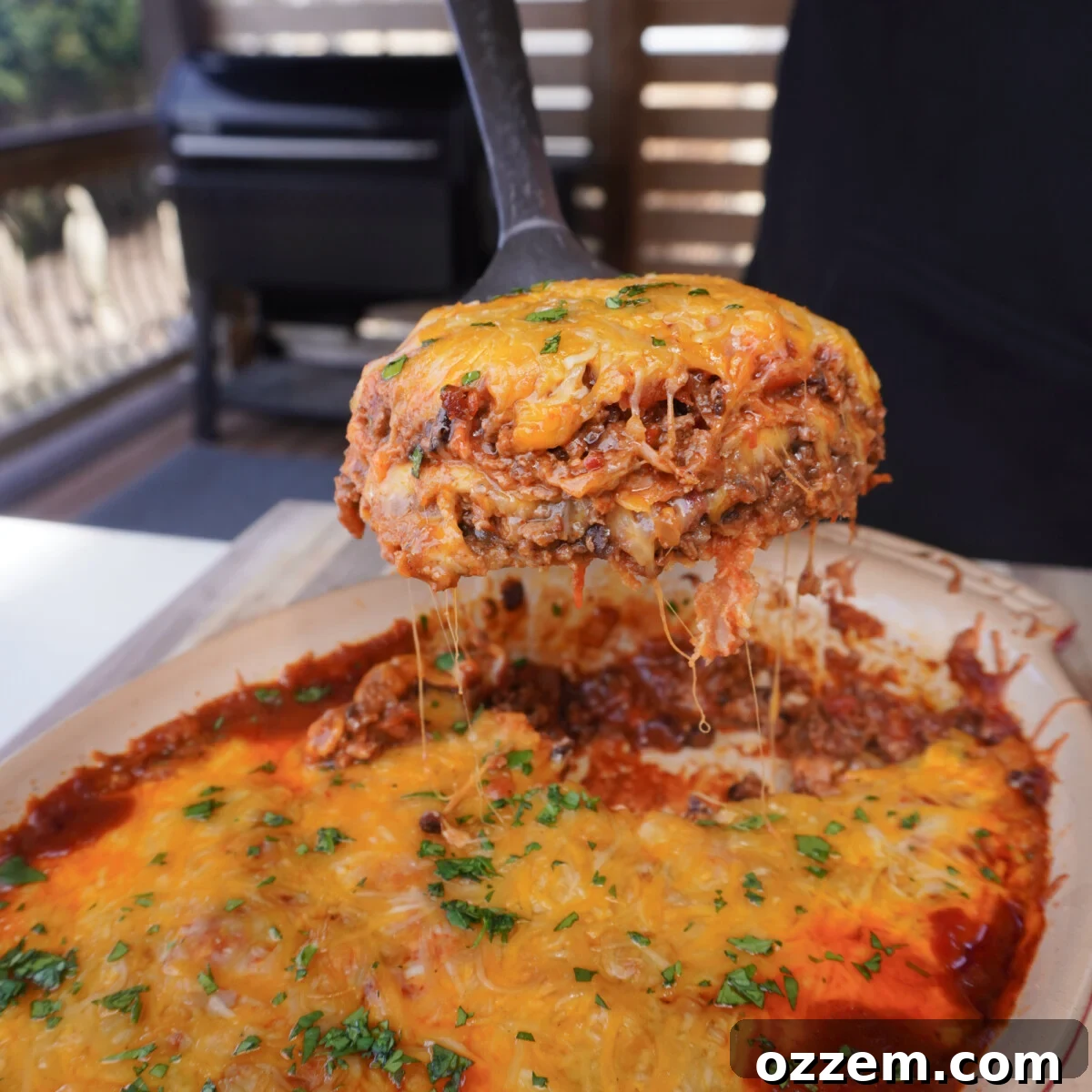 A delicious Smoked Beef Enchilada Casserole, freshly smoked and ready to serve, topped with melted cheese and fresh cilantro.