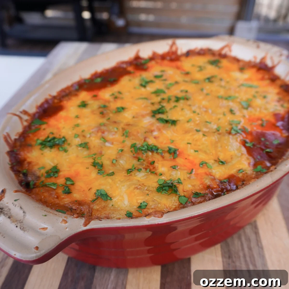 A freshly smoked beef enchilada casserole, garnished with bright green chopped cilantro, ready to be served.