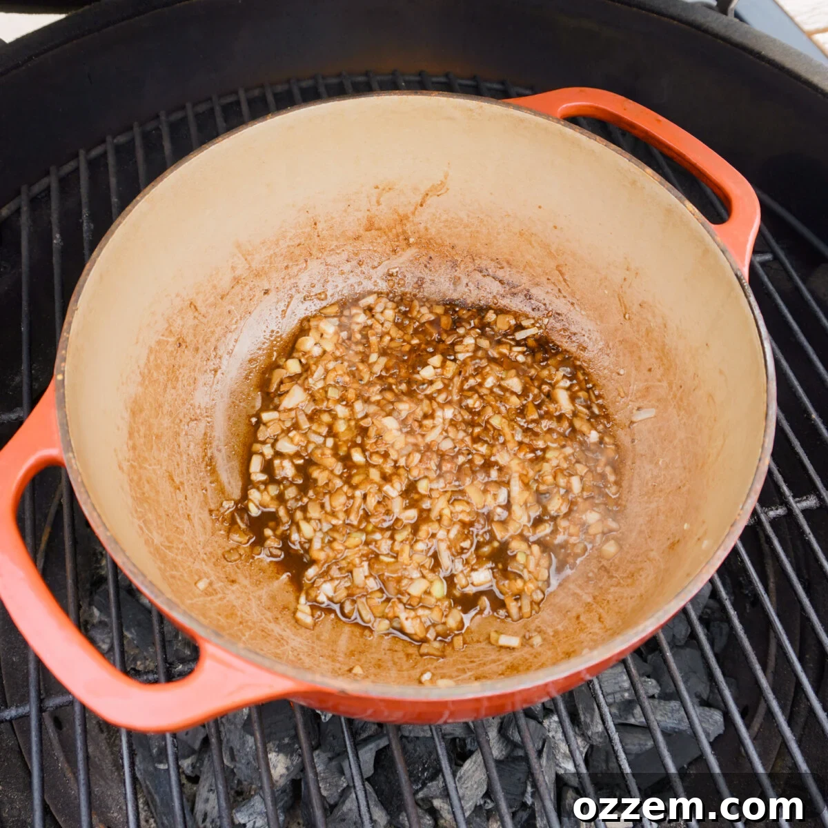 Smoked Chili Fire Dog 4 Finely chopped onions sautéing in a Dutch oven on a grill.