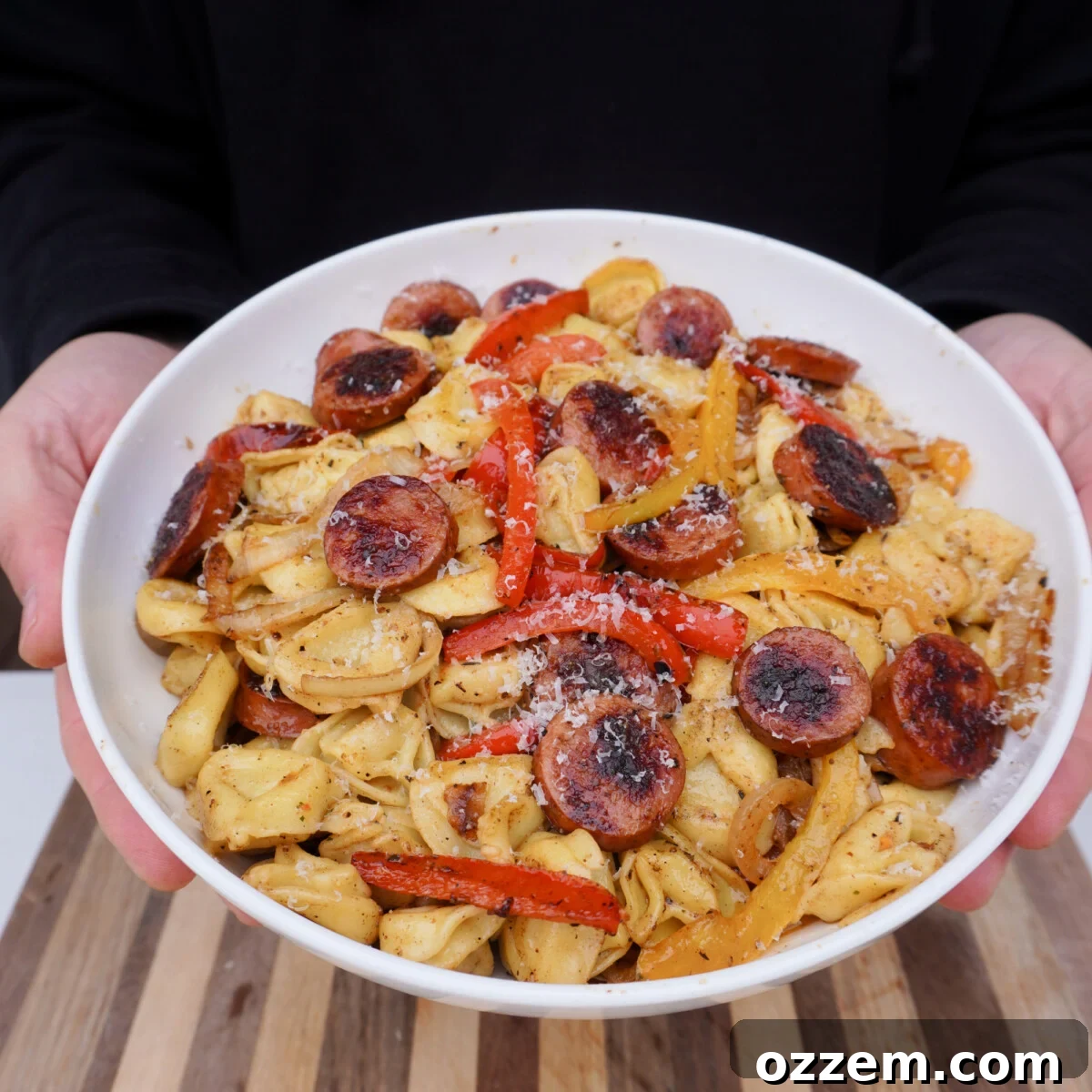 A beautifully plated Grilled Sausage and Tortellini Dinner, garnished with fresh Parmesan cheese, ready to be enjoyed as a satisfying meal.