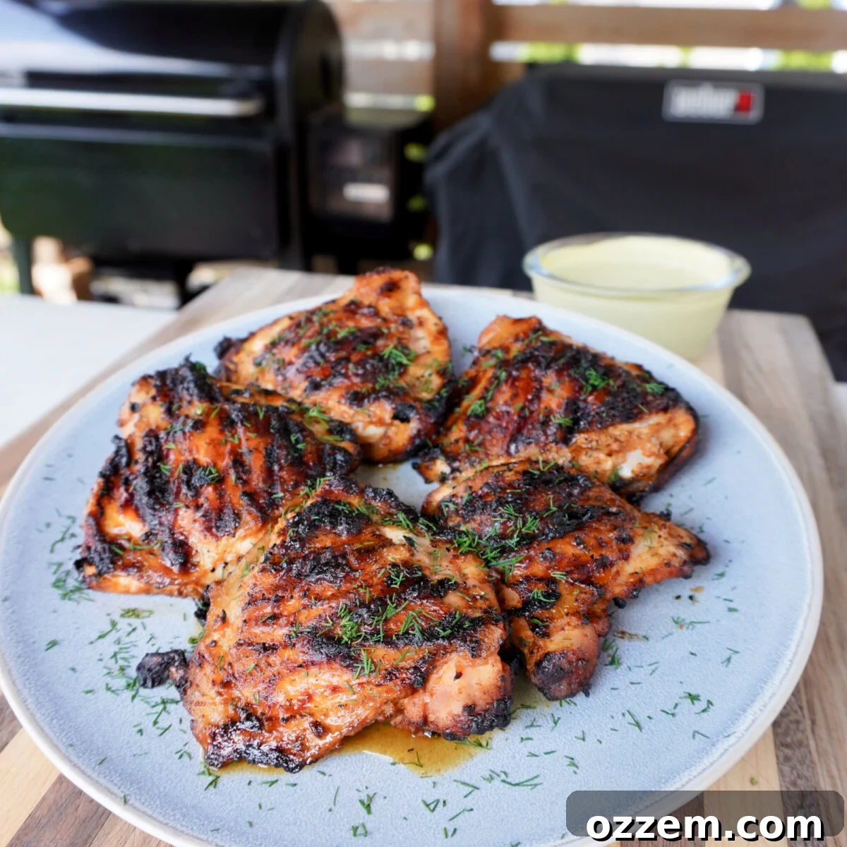 Perfectly grilled lemon dill chicken thighs served with a creamy dip, showcasing a delicious summer meal idea.