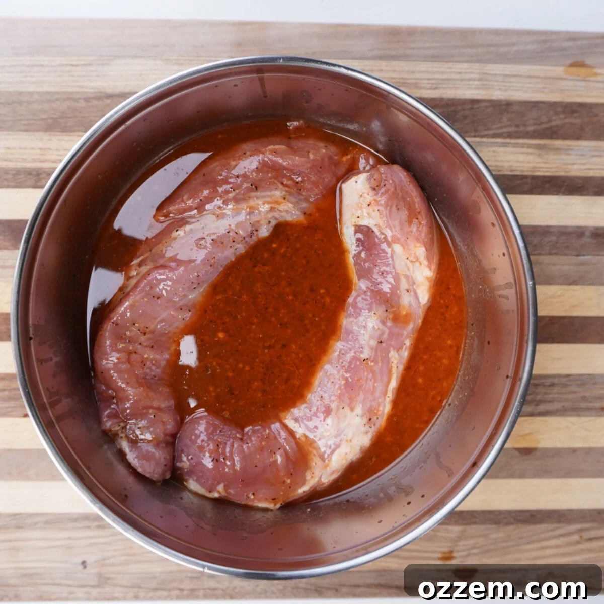 Sweet Meets Savory Pork Tenderloin 4 Pork tenderloins marinating in a sweet and savory sauce in a bowl.