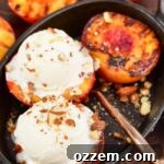 top view of grilled peaches topped with ice cream on a cast iron dish