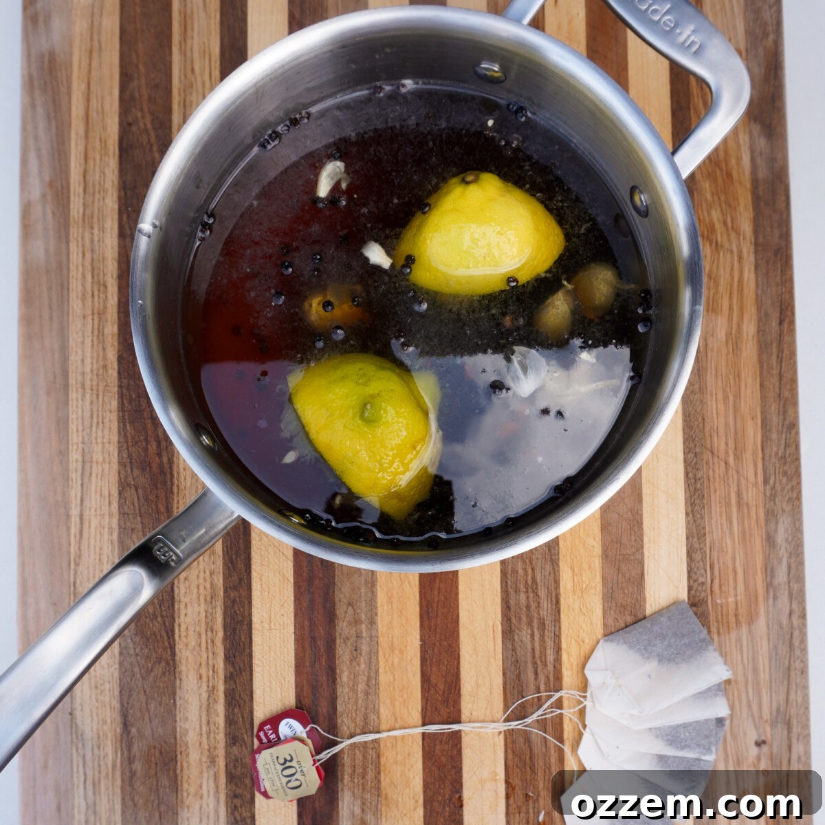 Sweet tea brine mixture in a saucepan, with tea bags steeping.