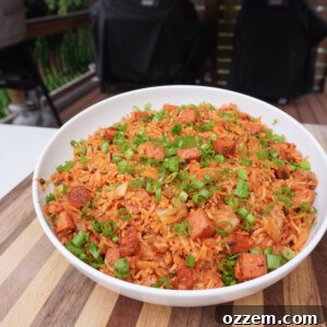 A vibrant bowl of Kimchi Fried Rice, garnished with fresh green onions and a perfect fried egg on top.