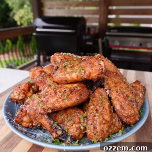 A plate of perfectly grilled cowboy butter chicken wings, glistening with sauce and garnished with fresh herbs, ready to be enjoyed.