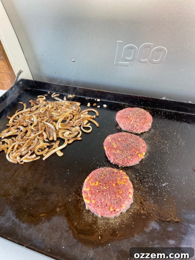 Texas BBQ Melt Sandwich 3 Onions caramelizing in bacon grease on a griddle.