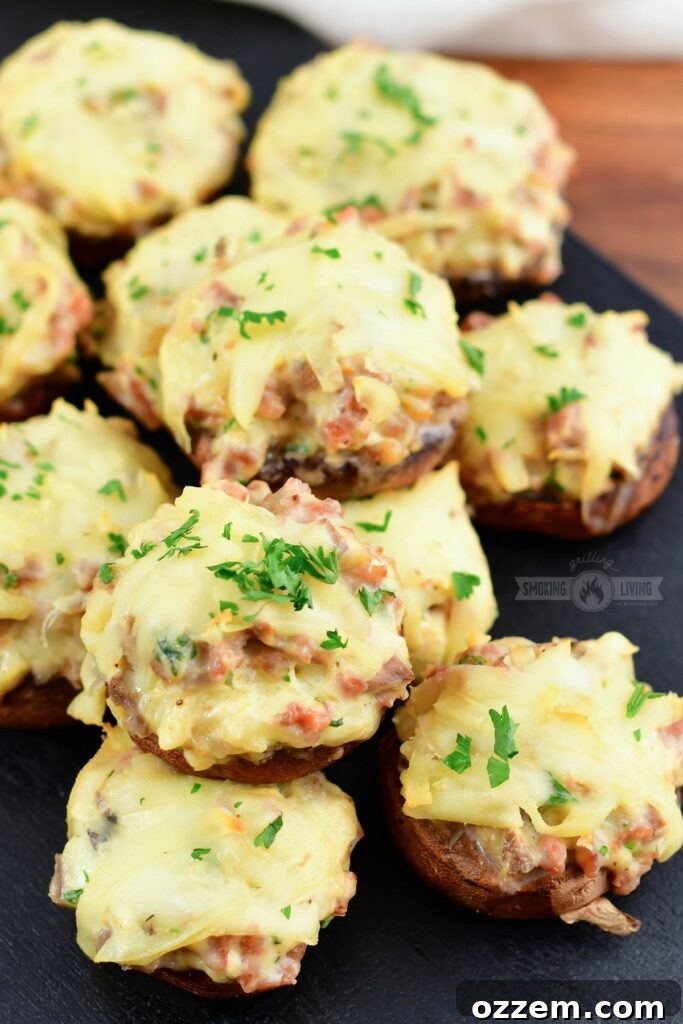 Close-up of deliciously smoked sausage stuffed mushrooms on a rustic cutting board, ready to be served as an appetizer.
