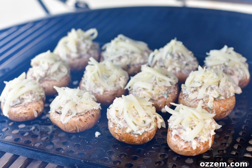 Smoked stuffed mushrooms cooking on the smoker grate, filling bubbling and cheese melting.