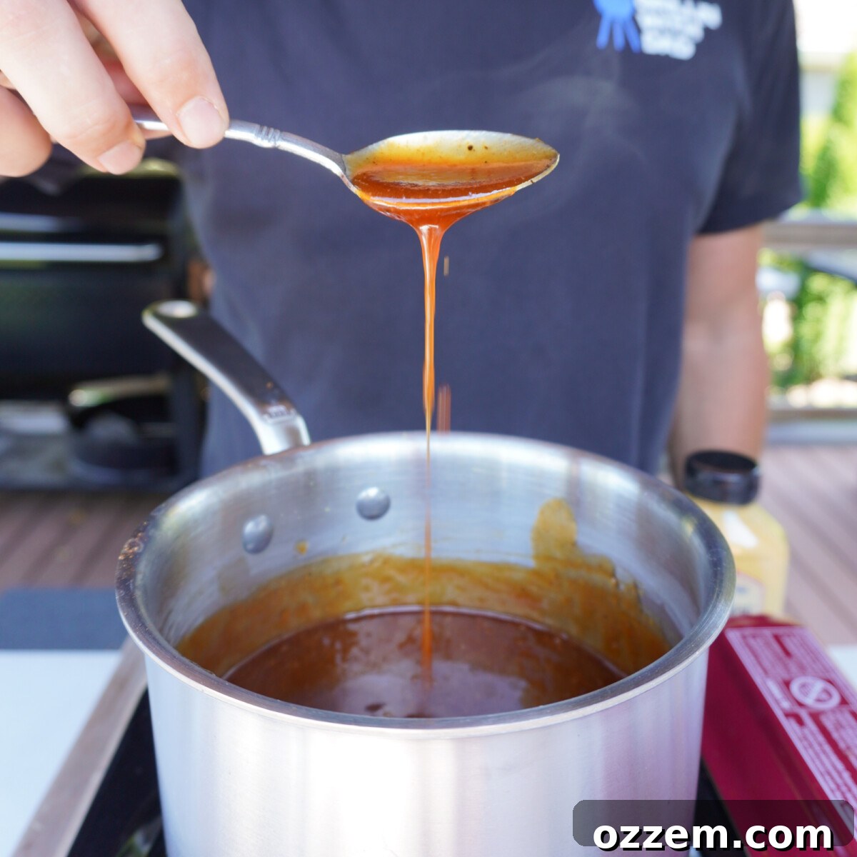 Southern Gold Smoked Pulled Pork 8 Carolina-style mustard BBQ sauce simmering gently in a saucepan on the stove.
