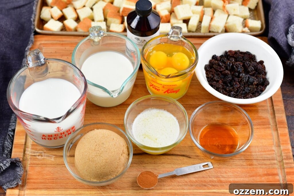 A collection of fresh ingredients for smoked bread pudding, including brioche bread, eggs, milk, cream, bourbon, raisins, and spices, neatly arranged on a wooden cutting board.