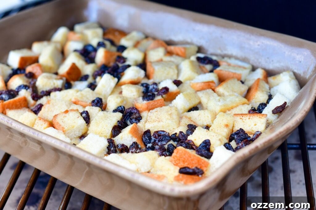Uncooked bread pudding in a baking dish, carefully placed on the grates inside a smoker.