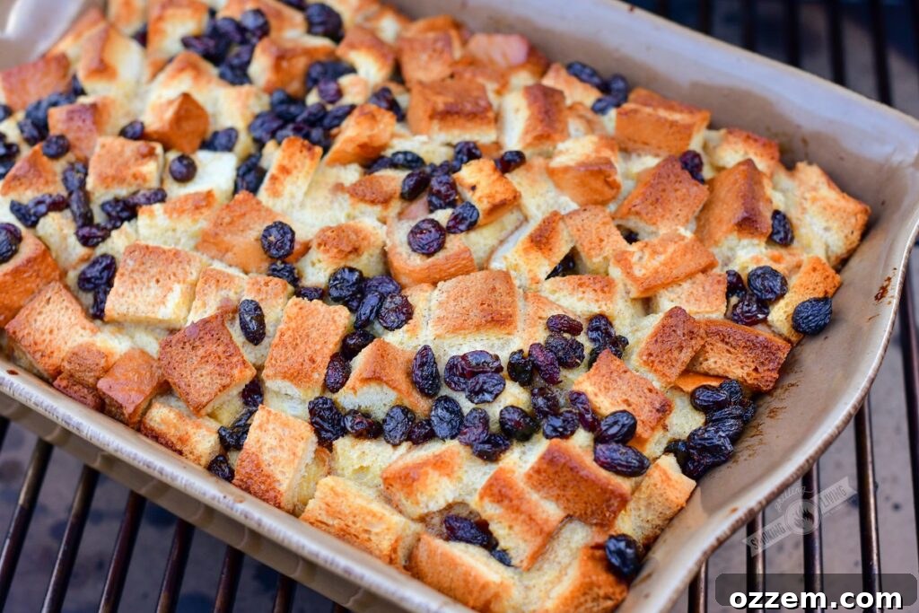 A beautifully baked smoked bread pudding, golden brown and slightly puffed, resting on the smoker grates after cooking.