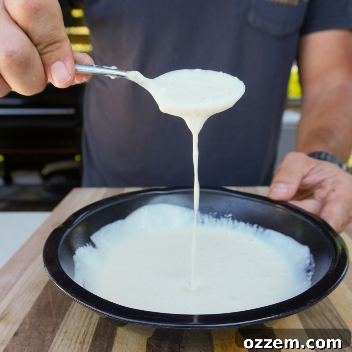 A small bowl of creamy garlic sauce with fresh chives.