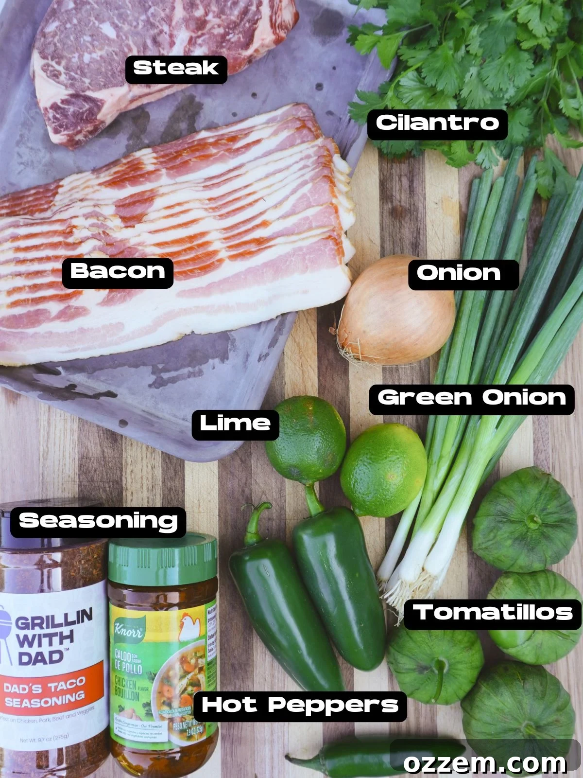 A vibrant display of fresh ingredients for Grilled Carne en su Jugo, including beef, tomatillos, peppers, and bacon.