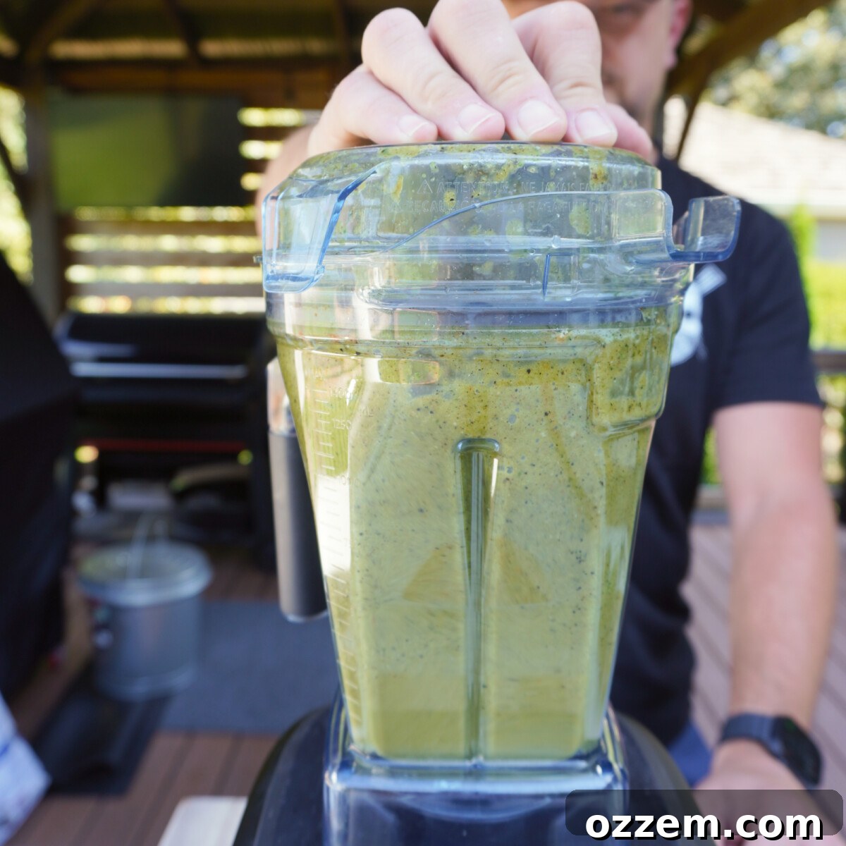 The charred salsa ingredients, including tomatillos, peppers, and onion, blended with cilantro and lime juice in a blender.