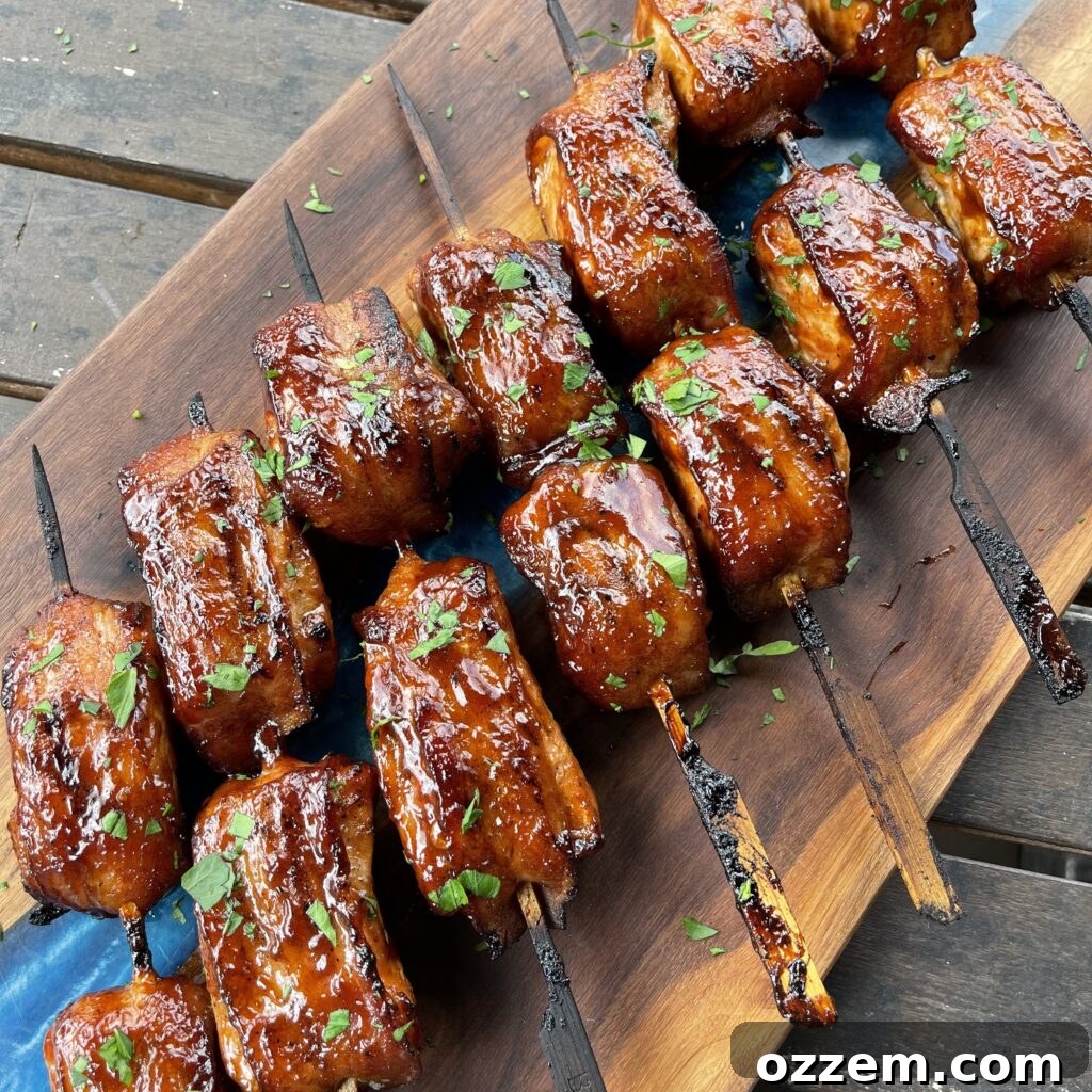 Savory Bacon Pork Skewers 2 Delicious sweet and spicy bacon wrapped pork skewers, perfectly grilled and ready to eat.