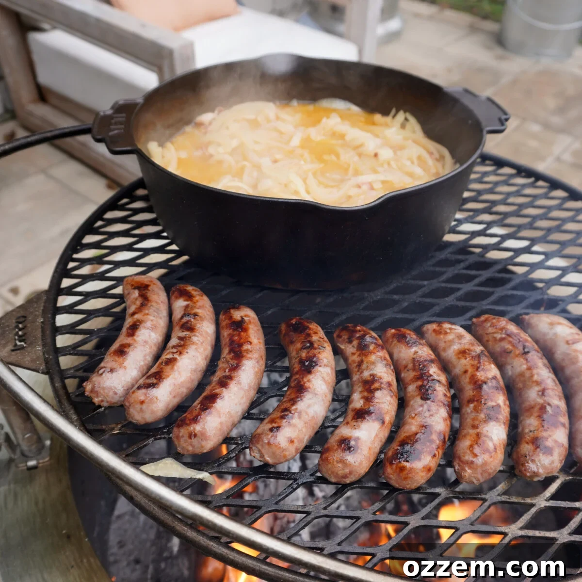 Bratwursts searing directly over an open flame on a grill, developing a beautiful char.