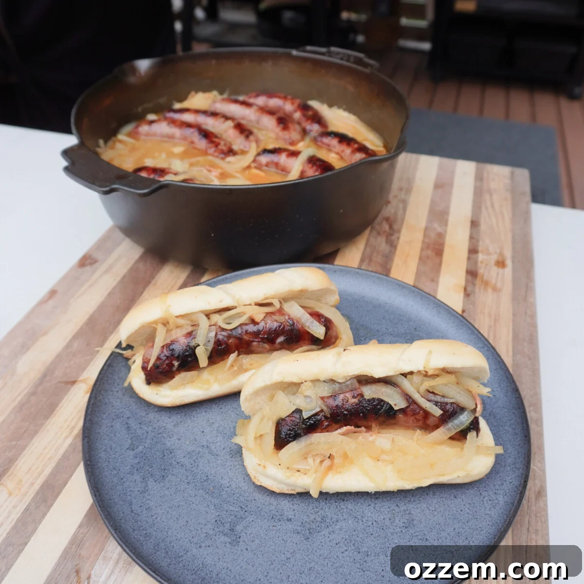 A perfectly grilled beer brat served in a pretzel bun with caramelized onions and mustard.