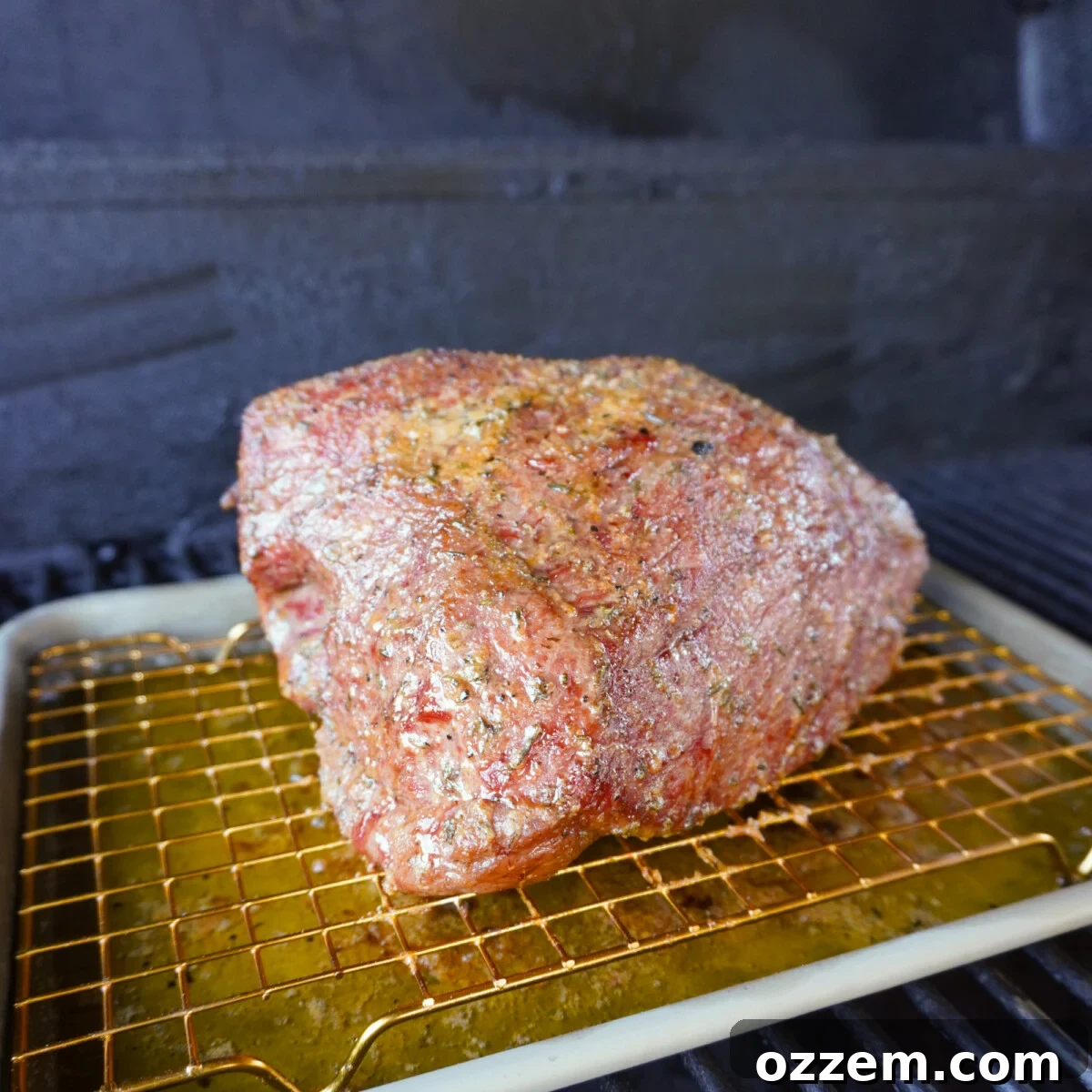 Garlic and Herb beef in a smoker on a wire rack.