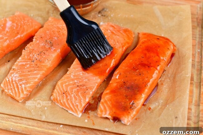 Caramelized Maple BBQ Grilled Salmon 5 Brushing a salmon fillet with maple BBQ glaze using a silicone brush before grilling