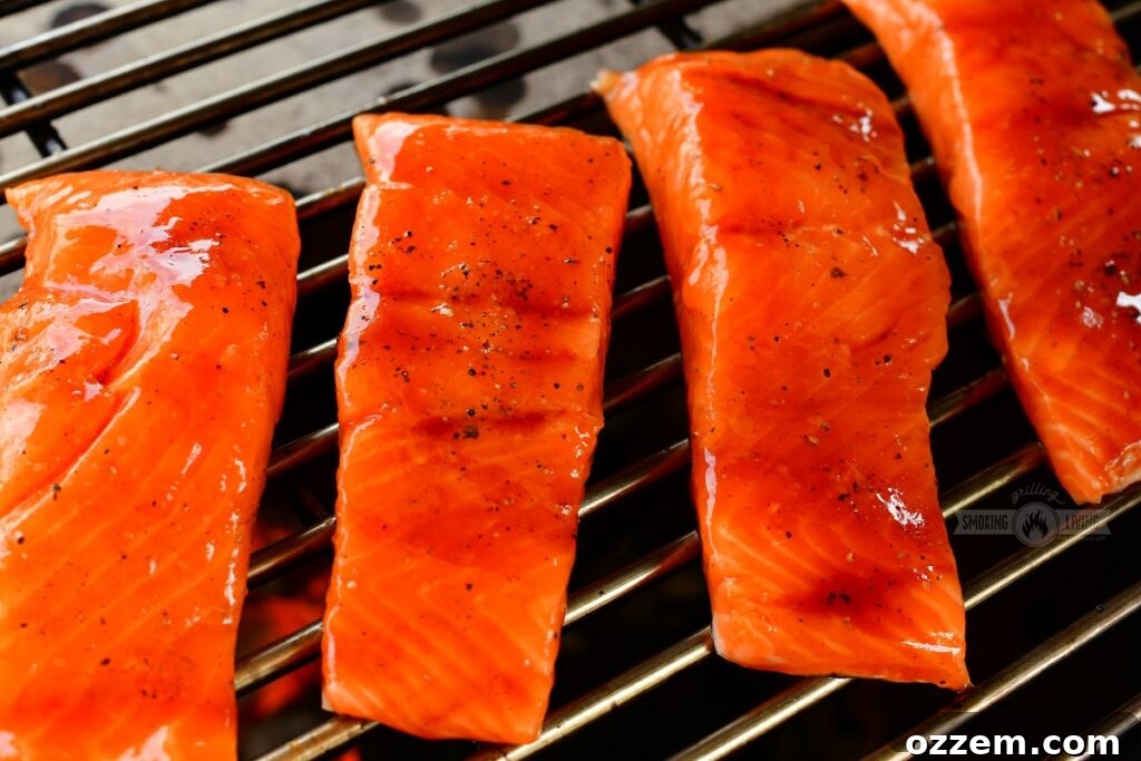Caramelized Maple BBQ Grilled Salmon 6 Salmon fillets on the grill with one being glazed