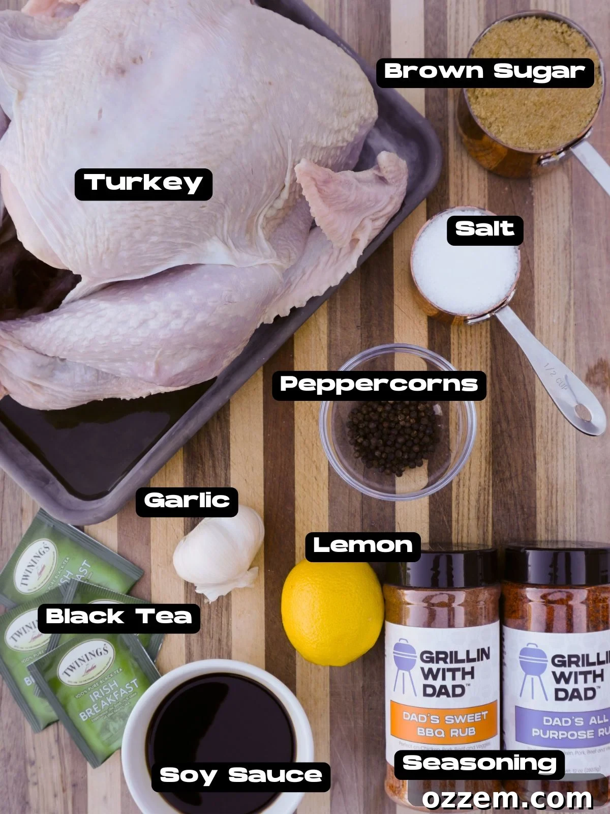 A selection of fresh ingredients including a turkey, black tea bags, brown sugar, lemons, salt, soy sauce, and peppercorns for the Sweet Tea Brine Grilled Turkey.