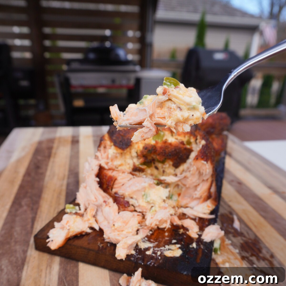 A fork full of the grilled jalapeno popper salmon, showcasing the filling.