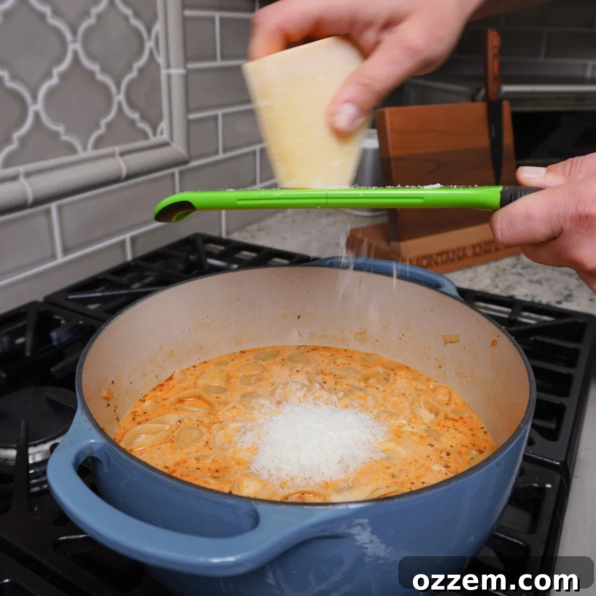Freshly grated Parmesan cheese being sprinkled over a simmering pot of Easy Marry Me Chicken Soup.