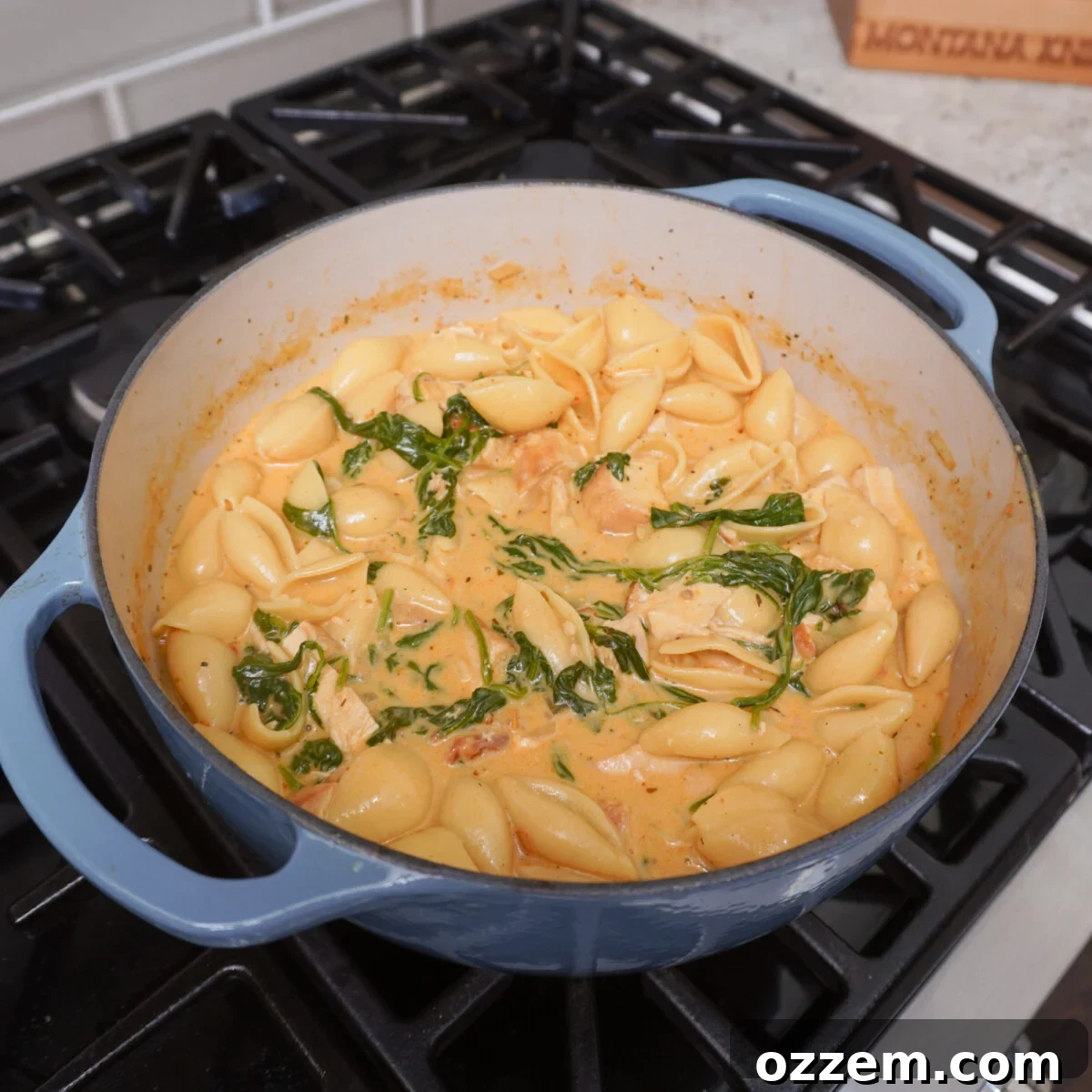 A large blue dutch oven filled with cooked Easy Marry Me Chicken Soup, ready to be served from the stovetop.