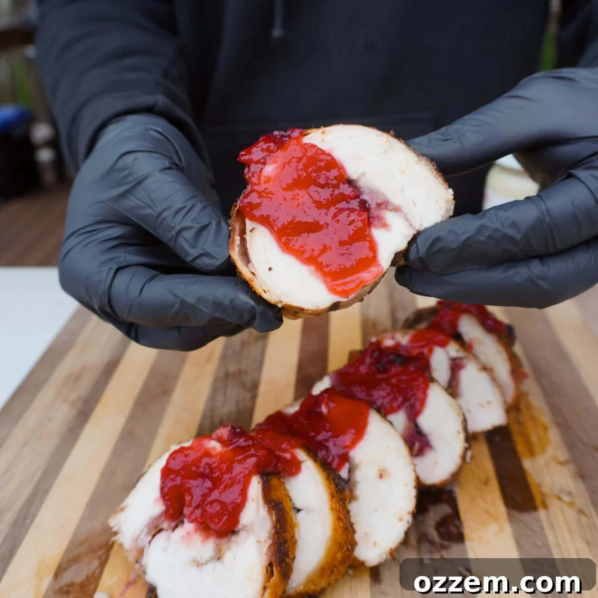 Cranberry Stuffed Turkey Breast slice held in hands.