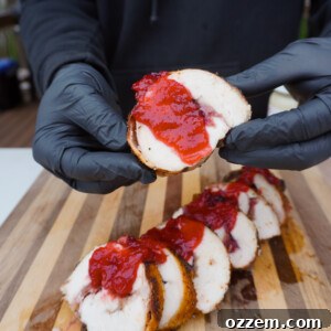 Cranberry Stuffed Turkey Breast slice held in hands.