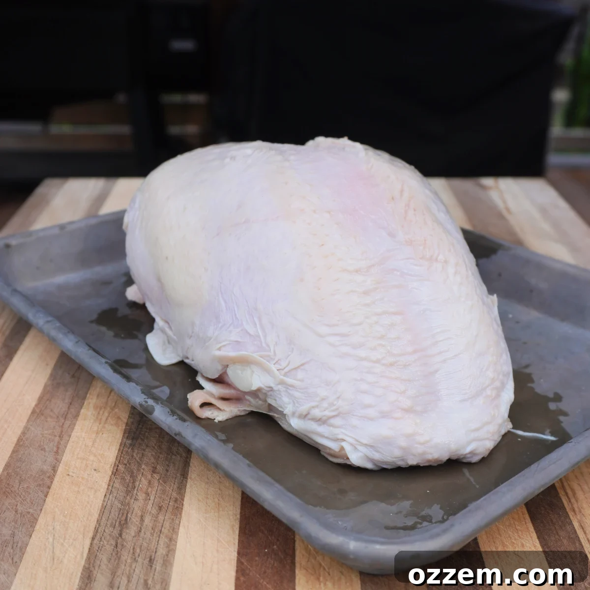 raw turkey breast on grey sheet pan.