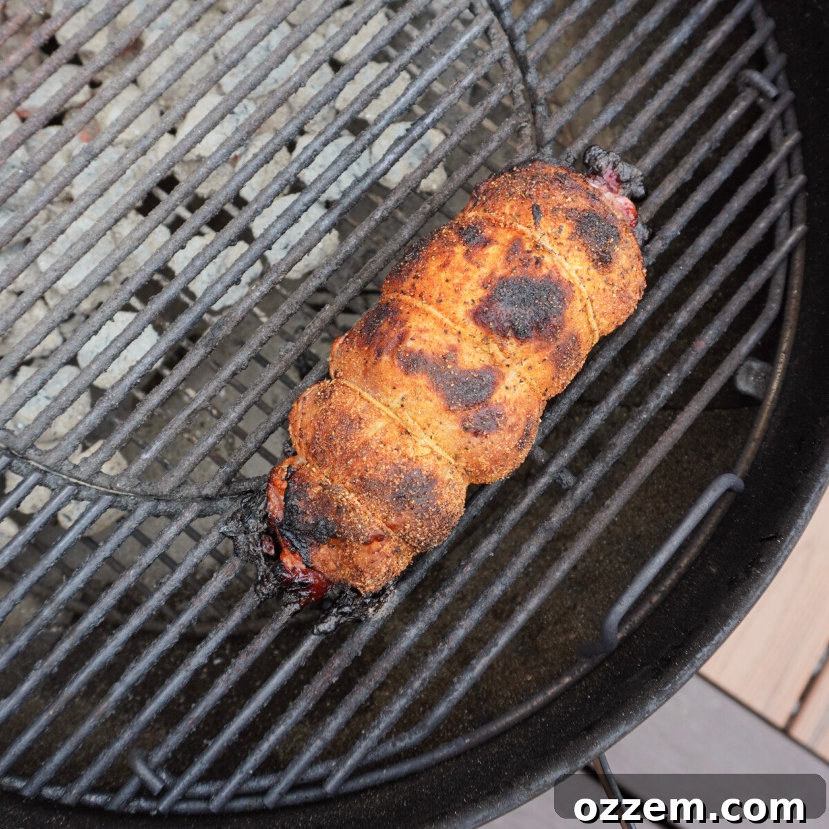 turkey roll cooking on charcoal grill.