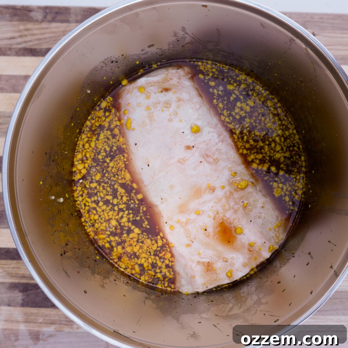 raw pork roast marinating in a apple cider marinade.
