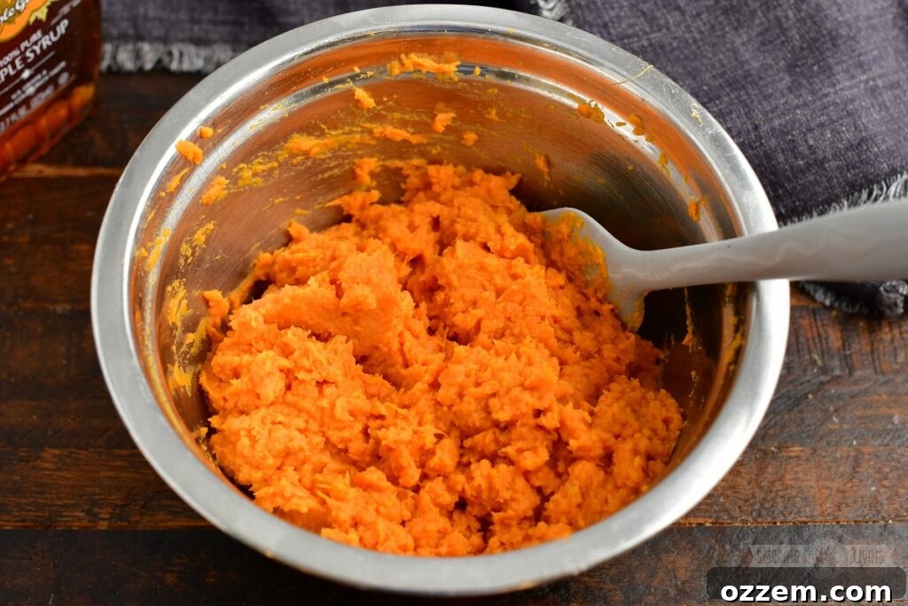 Mashed sweet potatoes in a mixing bowl, ready for the other casserole ingredients.