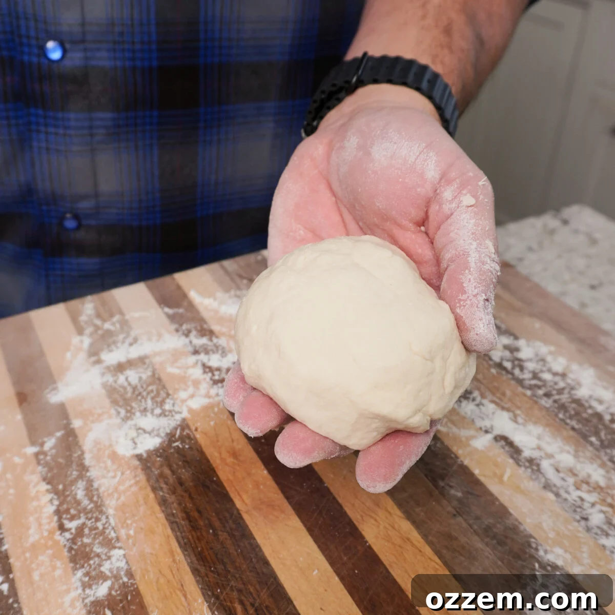BBQ Pulled Pork Pierogi 7 A smooth, round ball of pierogi dough on a wooden surface.