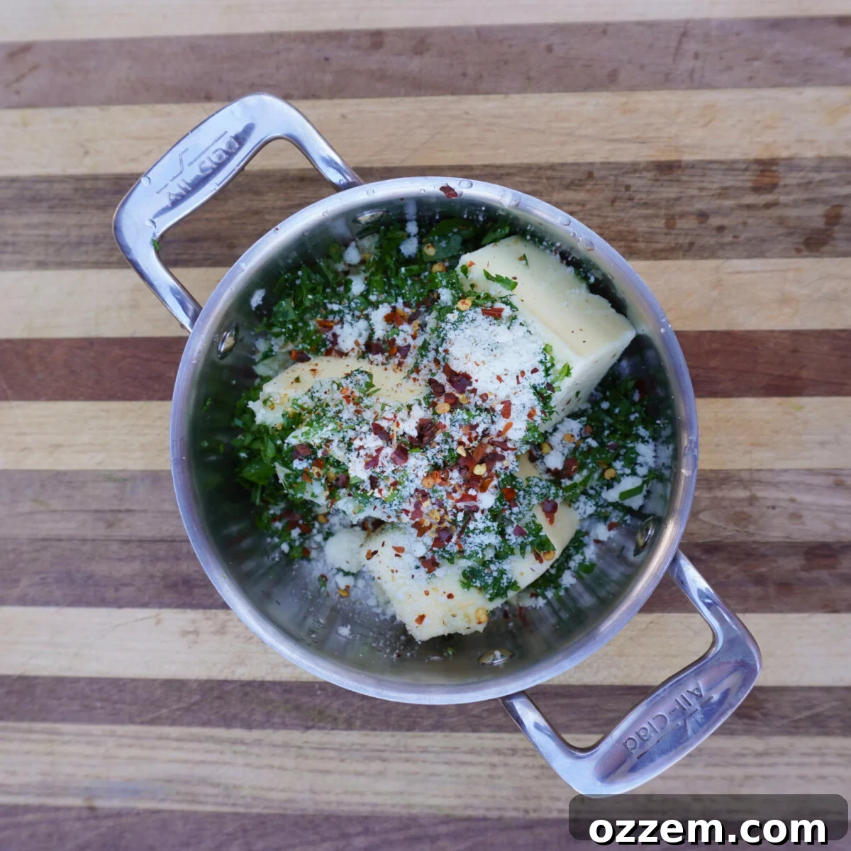 Garlic and herb butter ingredients in a saucepan, ready for melting.